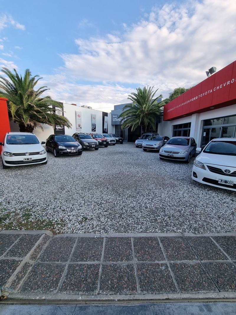 La playa de Autonor con los autos exhibidos y el local rojo y blanco a la derecha